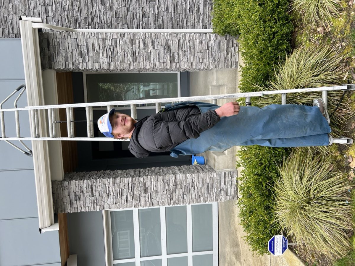 Dylan climbing a ladder to access a residential roof